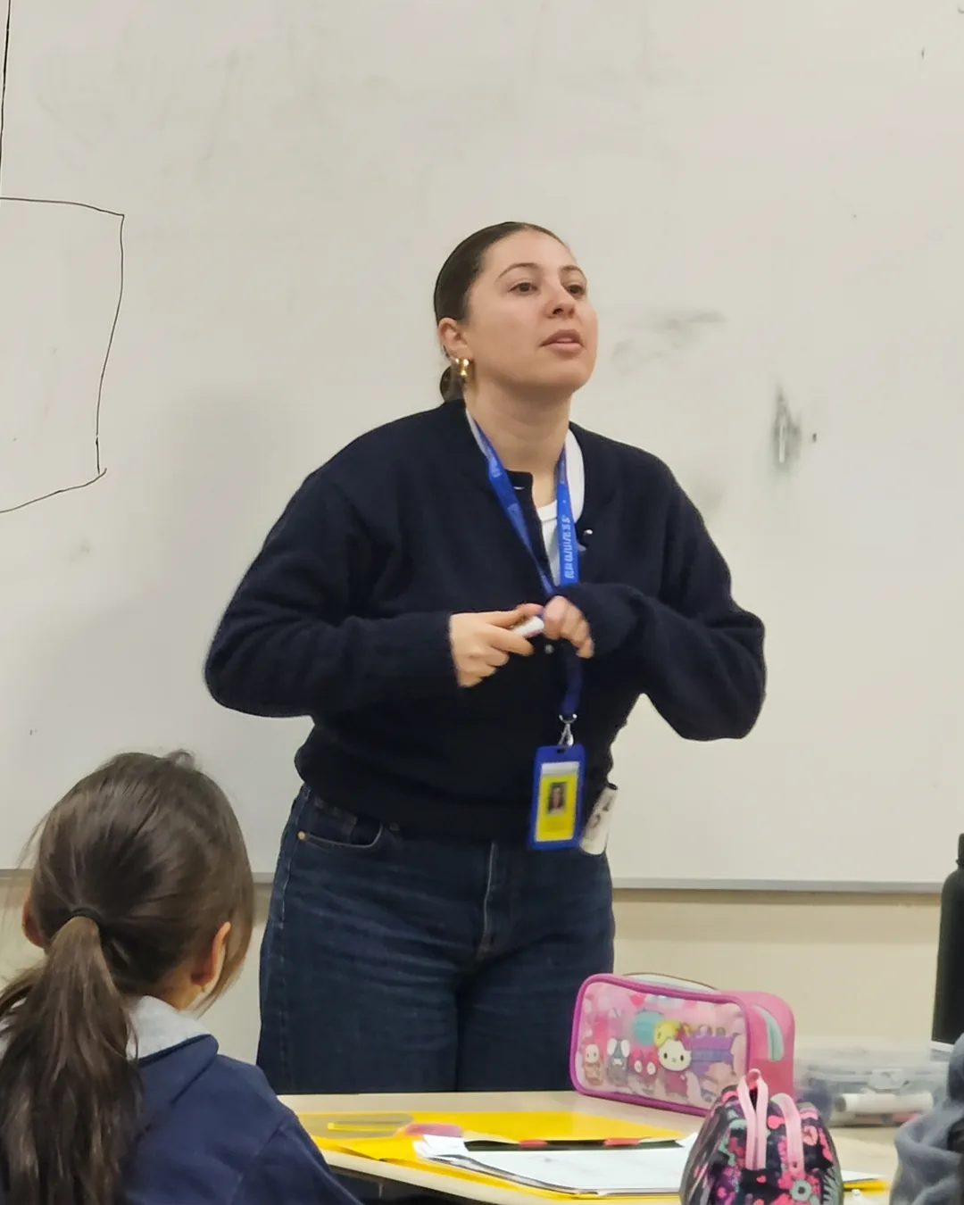 Isidora Benito (Miss Isi) de frente, explicando una clase de matemáticas frente a la pizarra